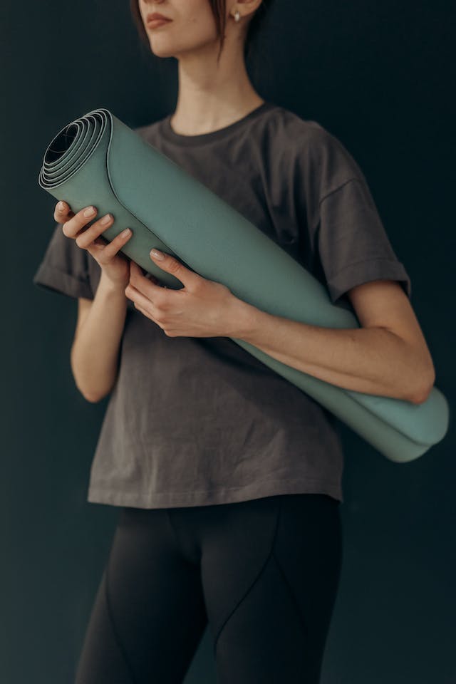 A woman preparing for a yoga session.